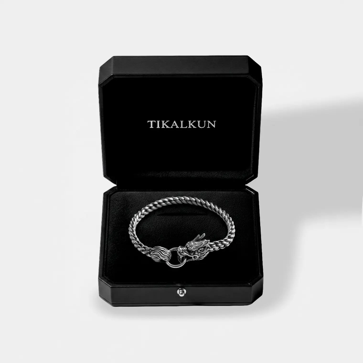 Silver bracelet with a dragon clasp in a black Tikalkun box on a light gray background