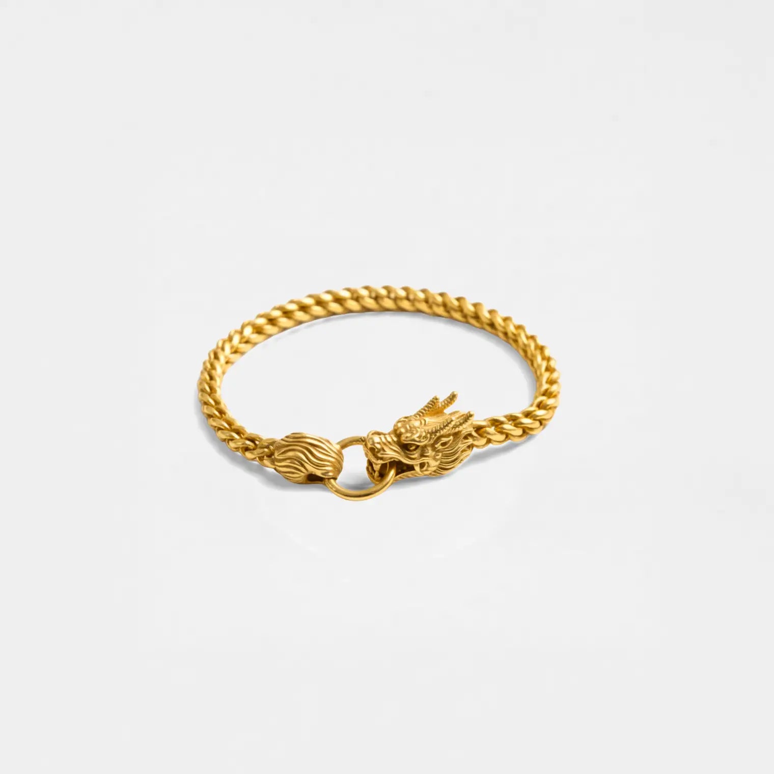 Gold bracelet with a dragon clasp on a light gray background