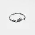 Silver chain bracelet with dragon clasp on a light gray background