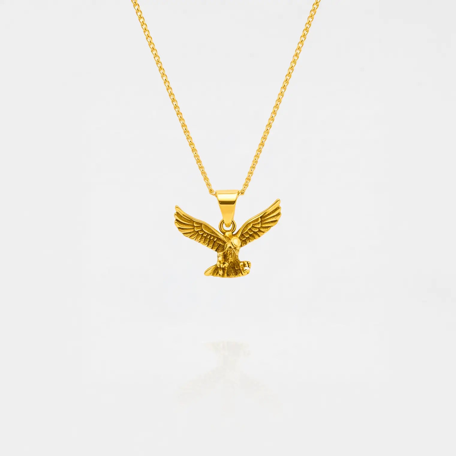 Gold eagle pendant necklace on a white background