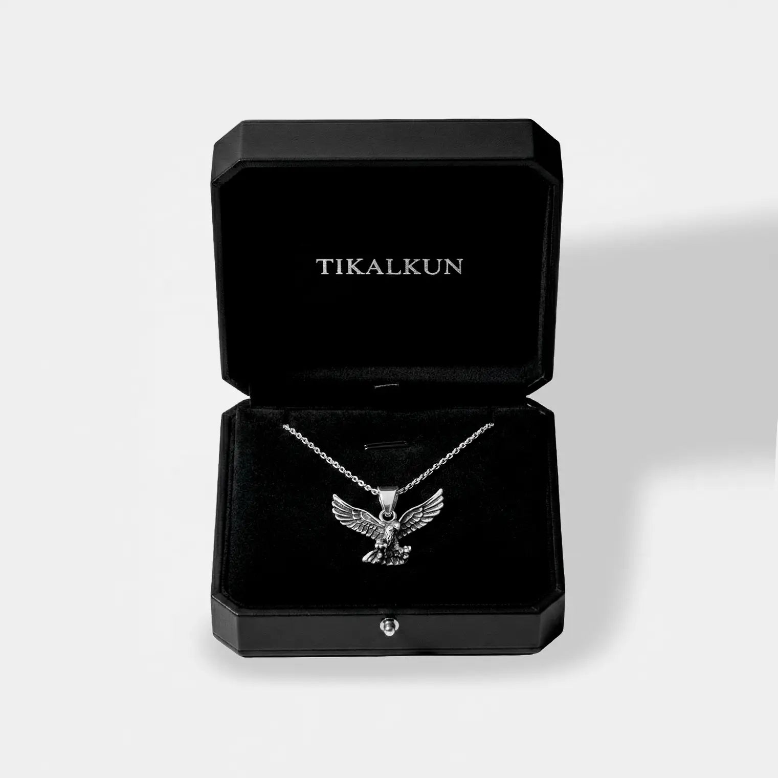 Silver eagle pendant necklace in a black Tikalkun jewelry box on a light gray background