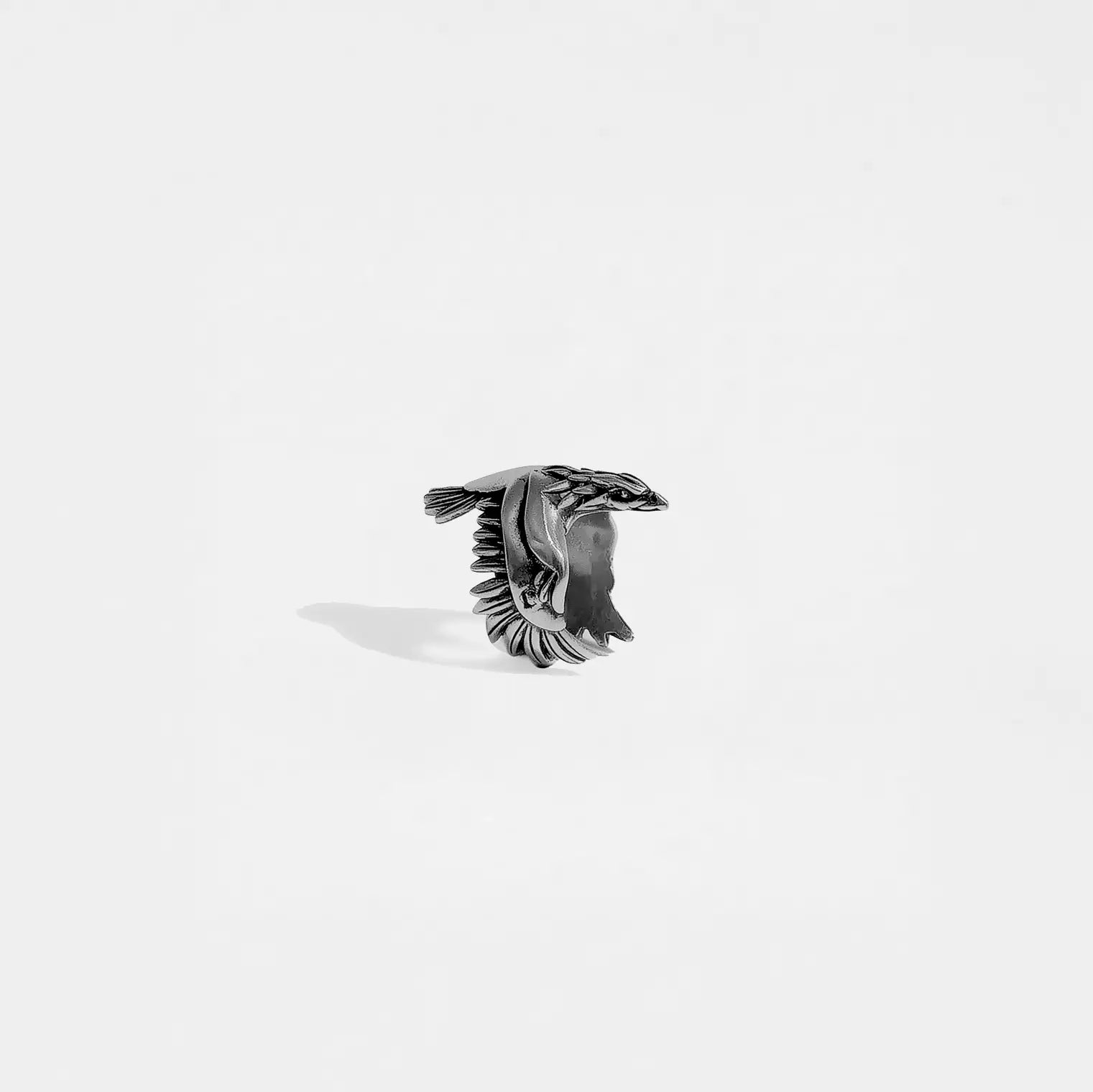 Silver ring with an eagle design on a white background