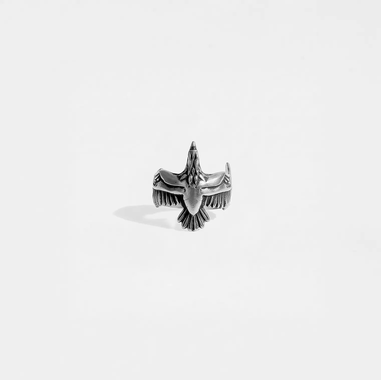 Silver eagle-shaped ring on a light gray background