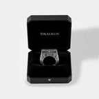 Silver egyptian ring in a black Tikalkun box on a light gray background