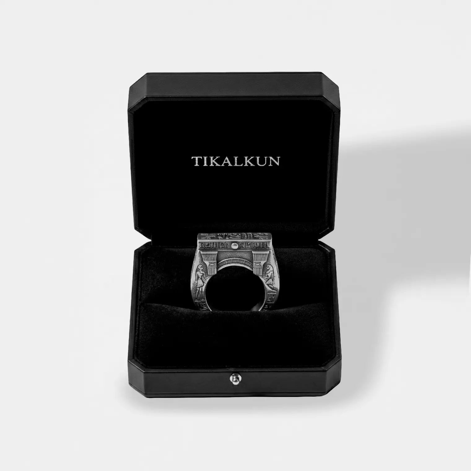Silver egyptian ring in a black Tikalkun box on a light gray background