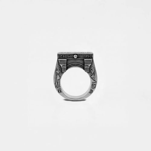 Silver ring with egyptian architecture design on a white background