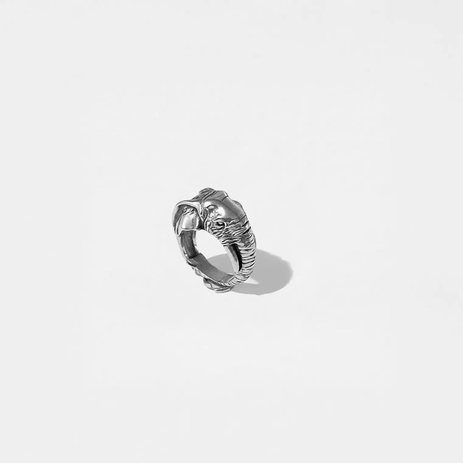 Silver ring with elephant design on a light gray background