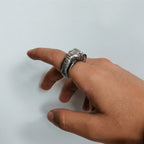 Hand wearing an elephant silver ring on a light gray background