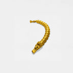 Gold bracelet with quetzalcoatl design on a white background