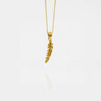 Gold feather pendant necklace on a white background