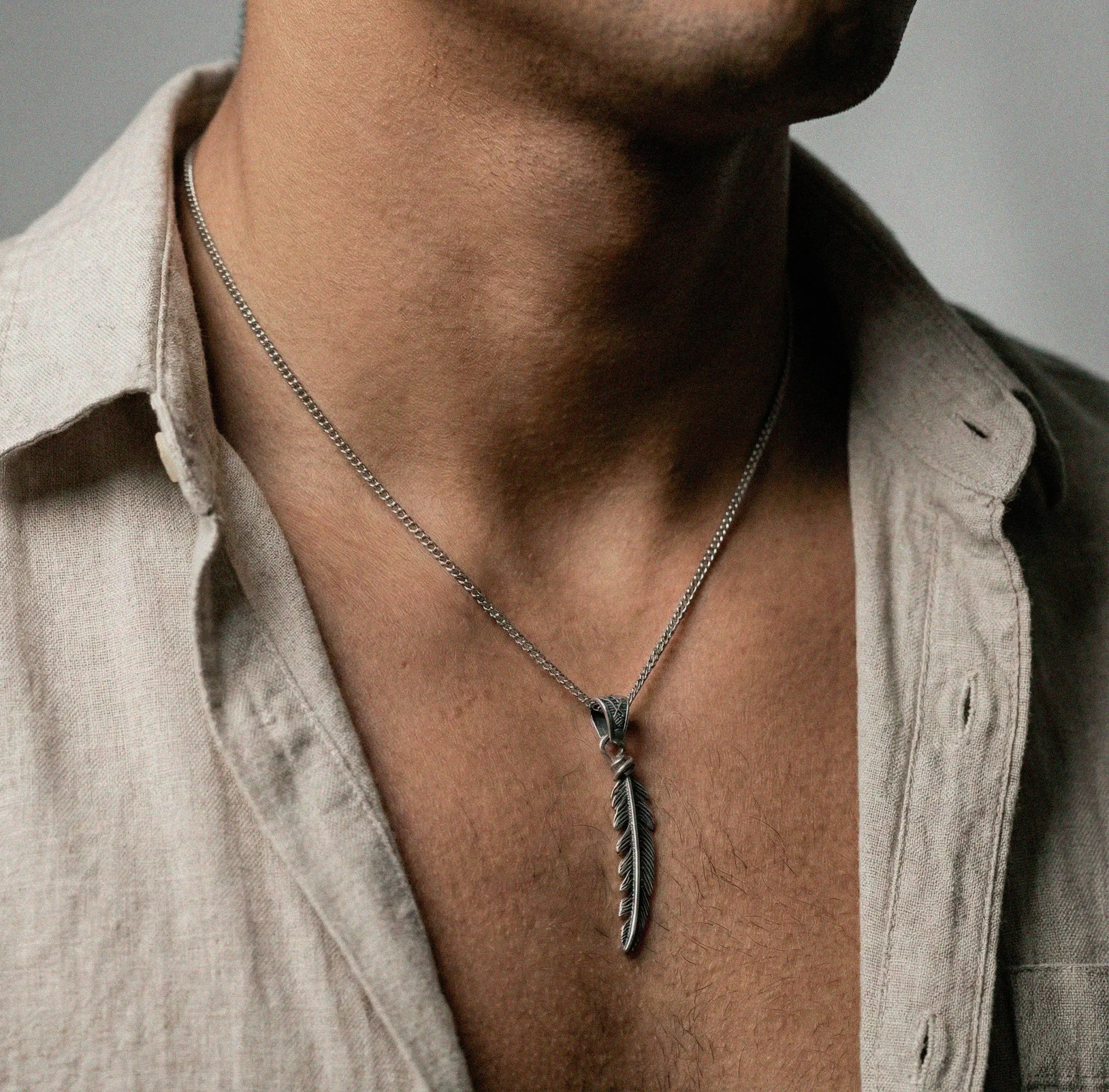 Necklace with a feather pendant worn by a person