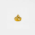Gold flame-shaped ring on a light gray background