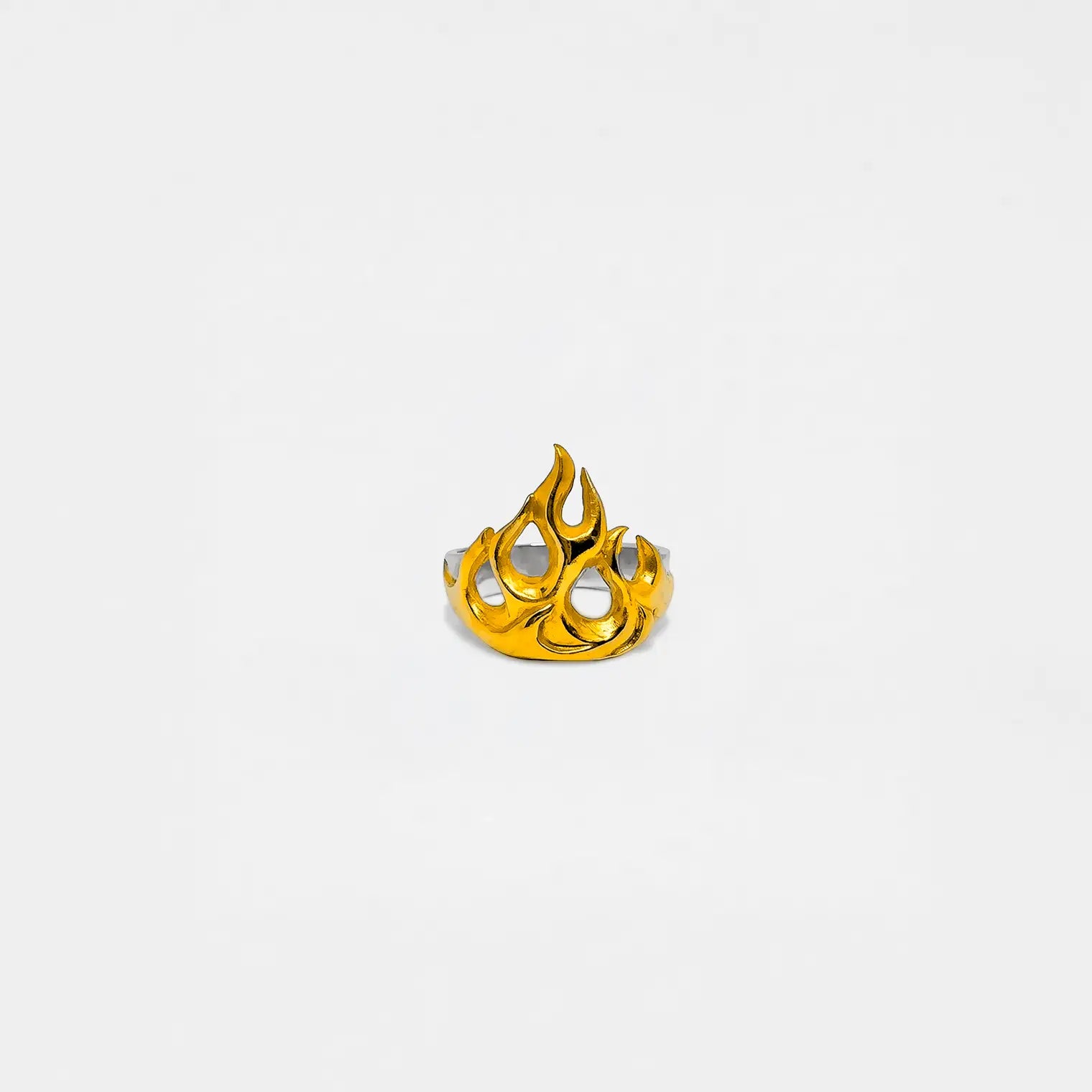 Gold flame-shaped ring on a light gray background
