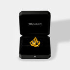 Gold ring with a fire-flame design in a black Tikalkun box on a light gray background