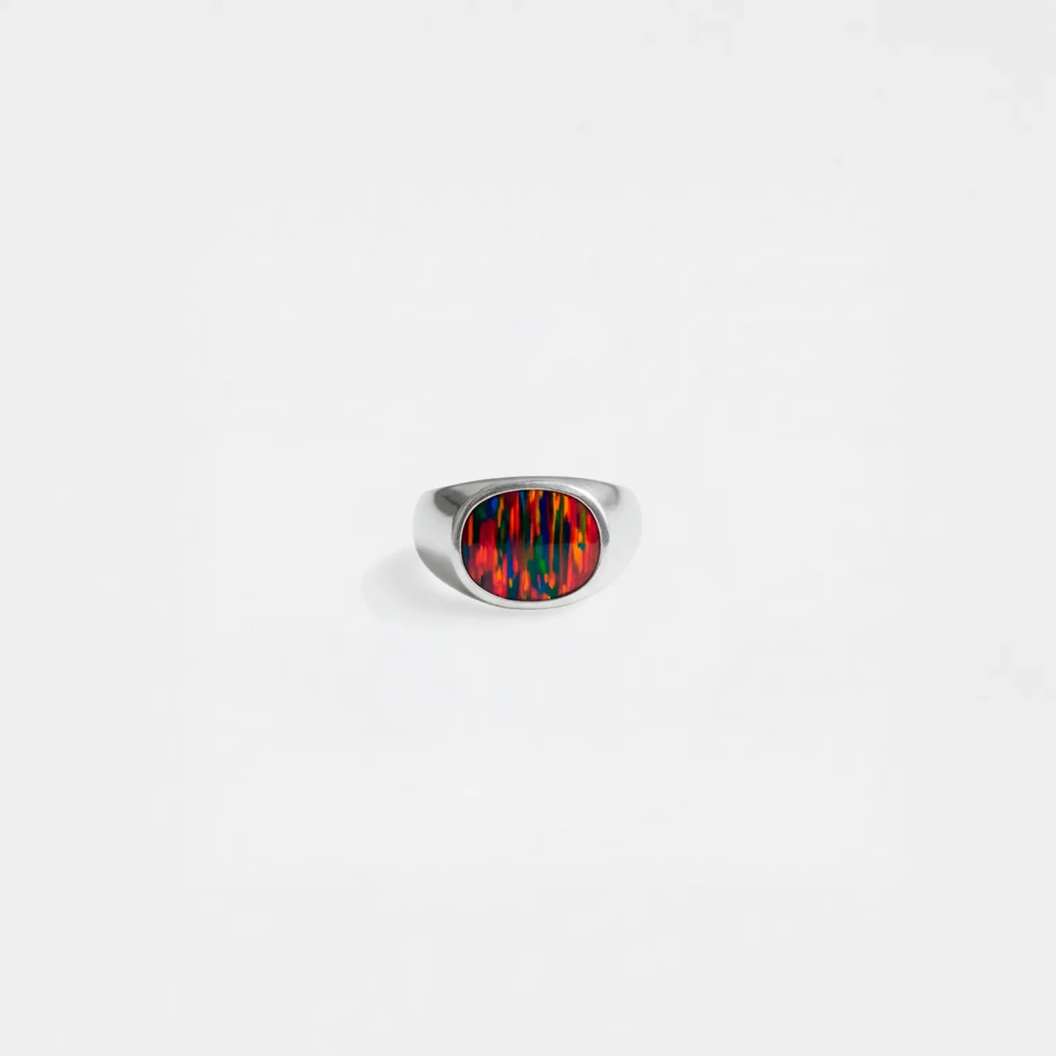 Silver ring with an opal fire stone on a white background