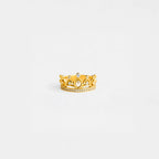 Gold crown ring with gemstones on a light gray background