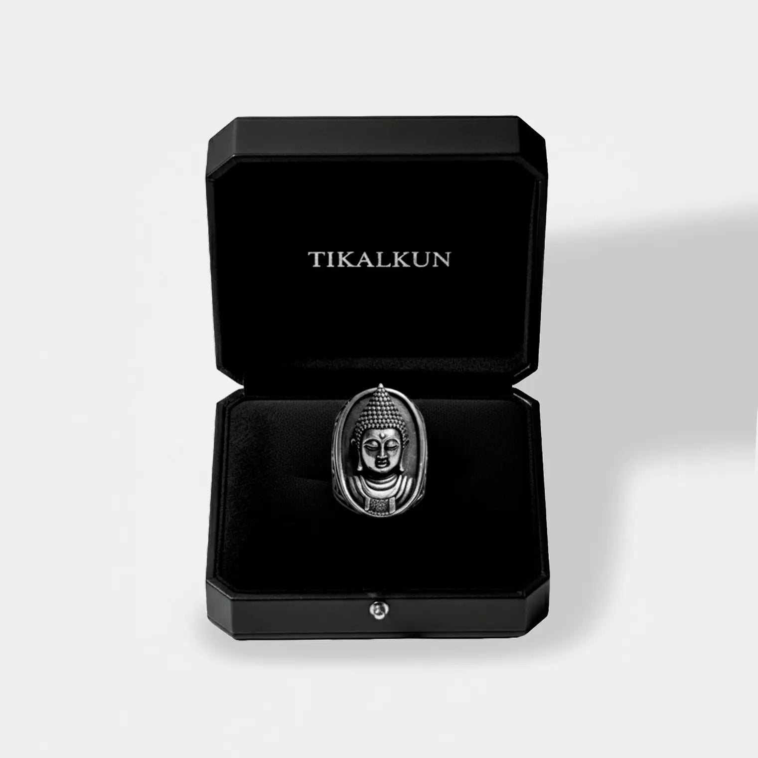 Silver Buddha ring in a black Tikalkun jewelry box on a light gray background