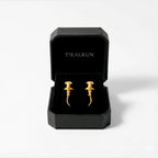 Gold  hammerhead-shark earrings in a black Tikalkun box on a white background