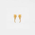 Pair of gold hammerhead-shark earrings on a light gray background