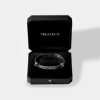 Silver bracelet in a black Tikalkun box on a light gray background