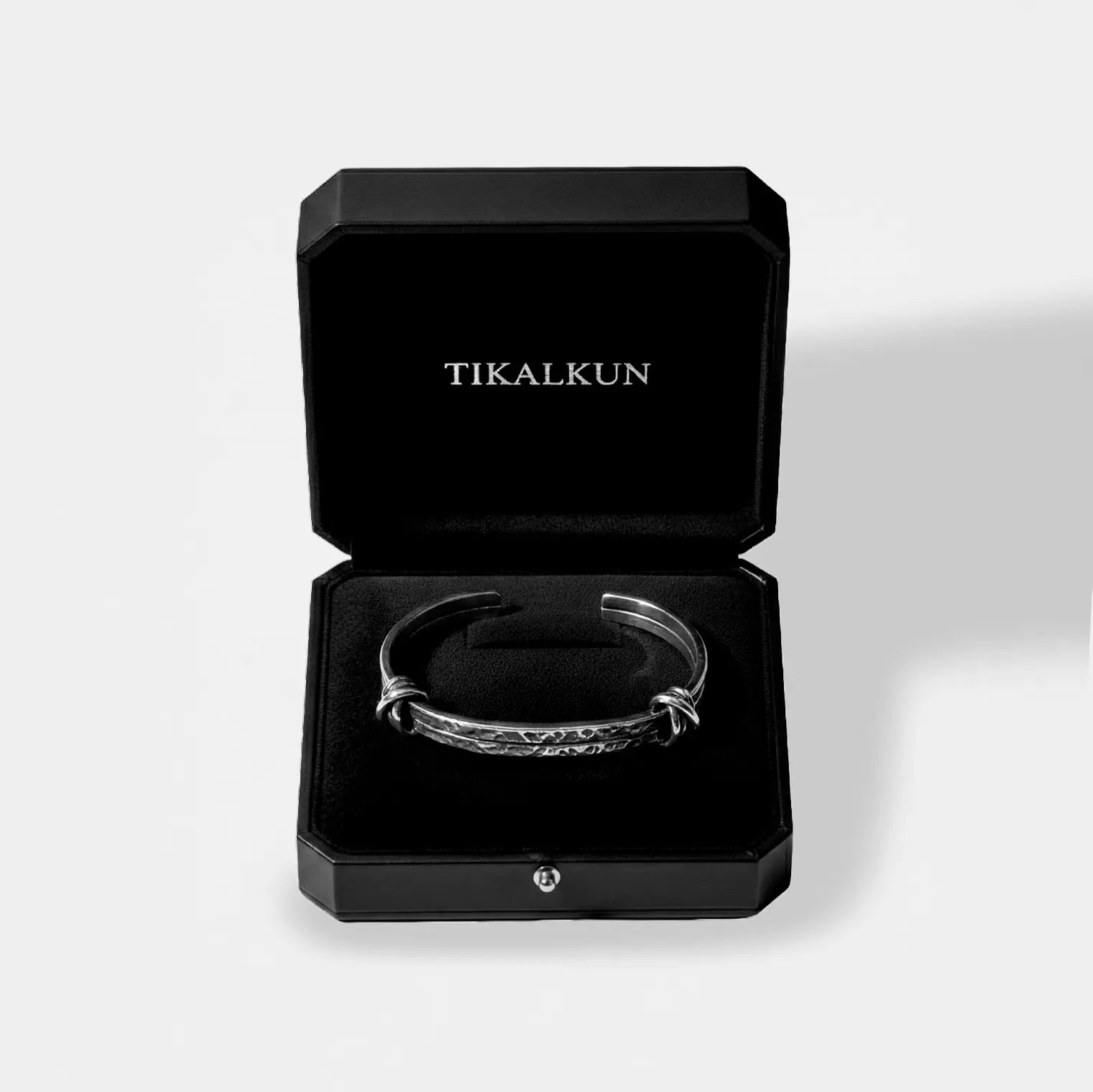 Silver bracelet in a black Tikalkun box on a light gray background