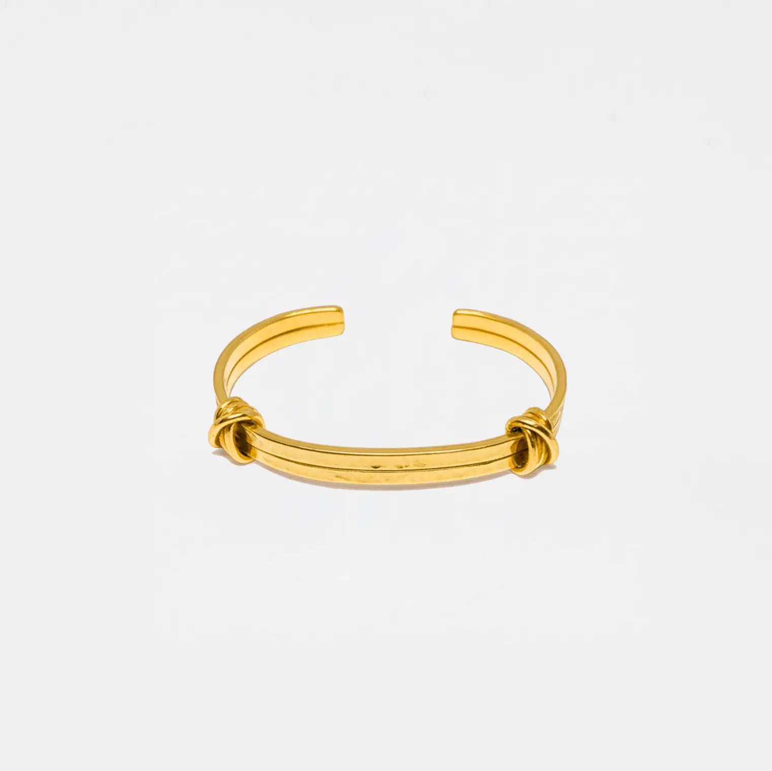 Gold bracelet on a light gray background