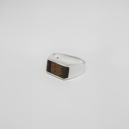 Handcrafted silver ring with a rectangular Tiger's Eye gemstone centerpiece on a clean white background