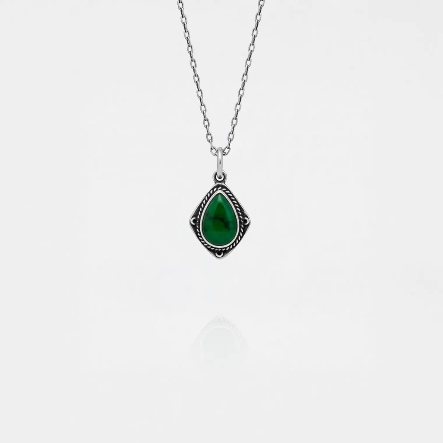 Necklace with a jade teardrop pendant on a white background