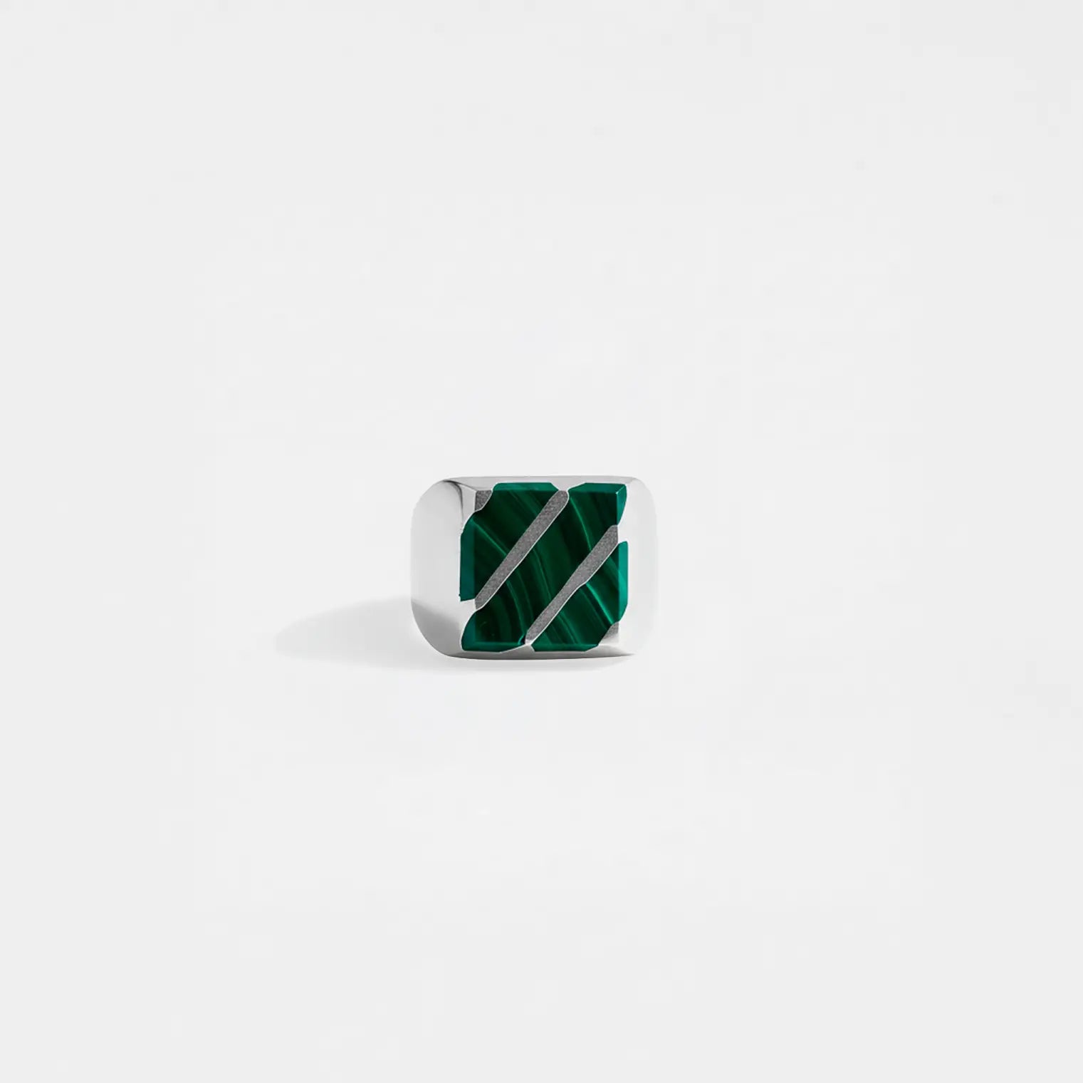 Silver ring with green gemstone on a white background