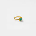 Gold ring with a green gemstone on a white background