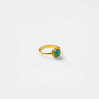 Gold ring with a green gemstone on a white background