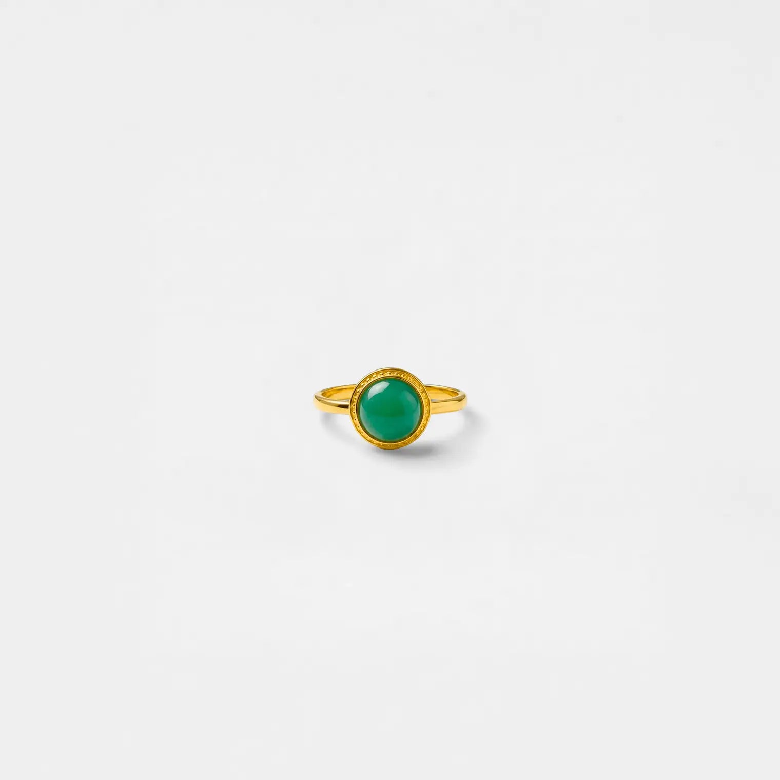 Gold ring with a jade gemstone on a white background