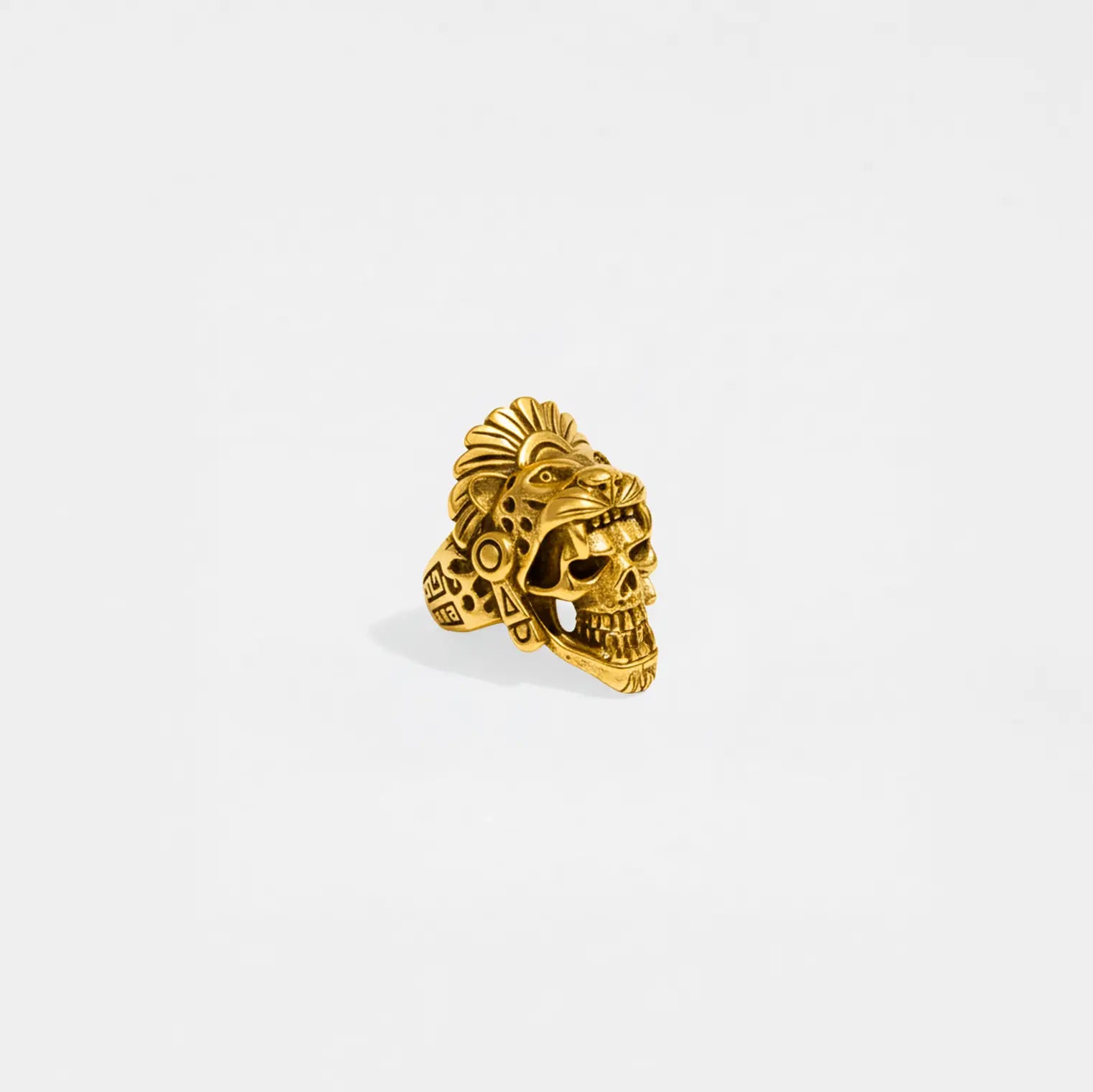 Gold jaguar-warrior skull ring on a light gray background