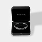 Silver bracelet in a black Tikalkun box on a light gray background