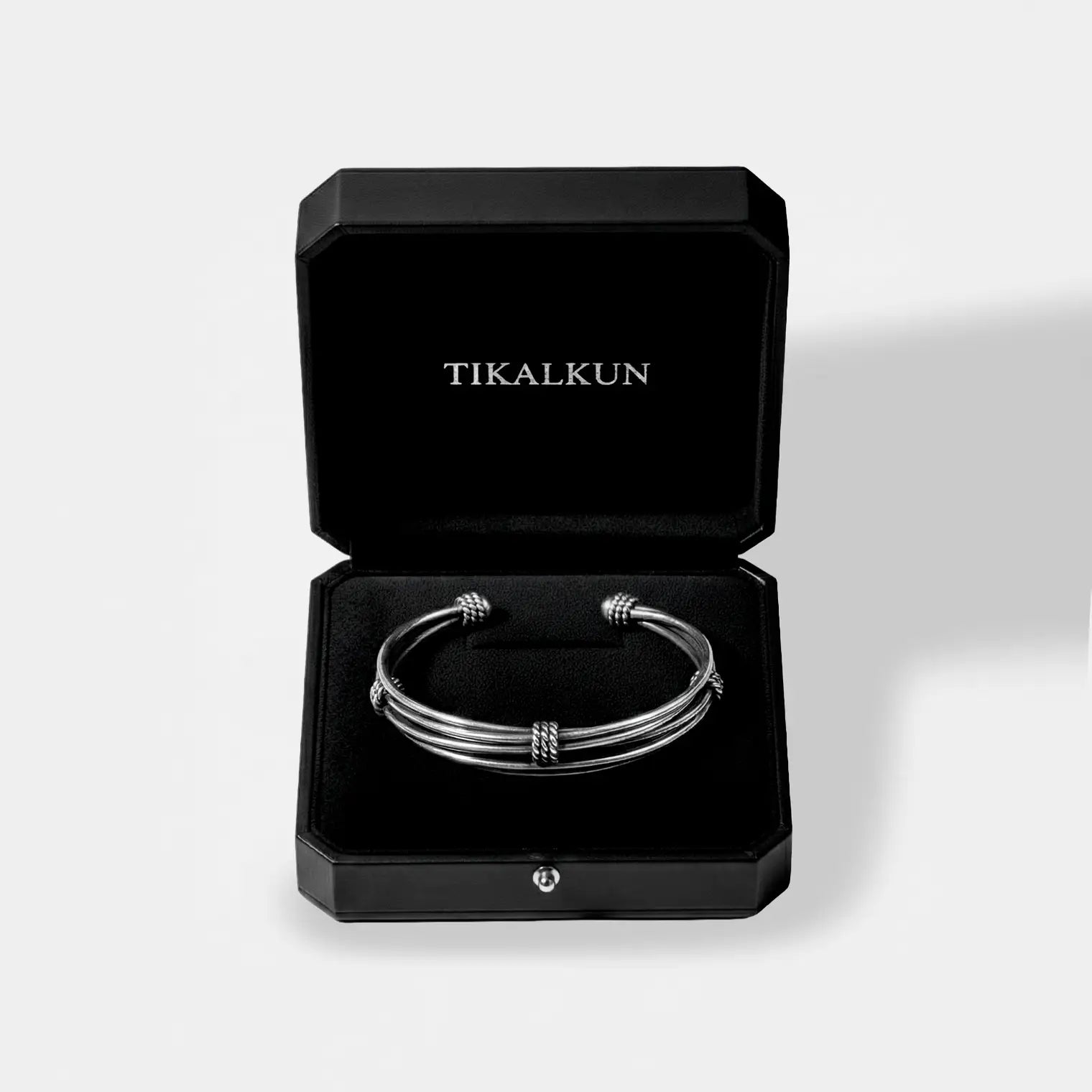 Silver bracelet in a black Tikalkun box on a light gray background