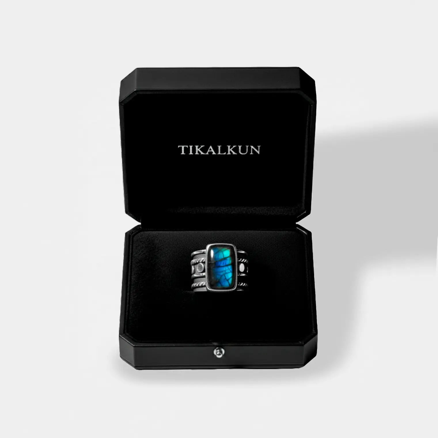 Ring with labradorite stone in a black Tikalkun box on a light gray background