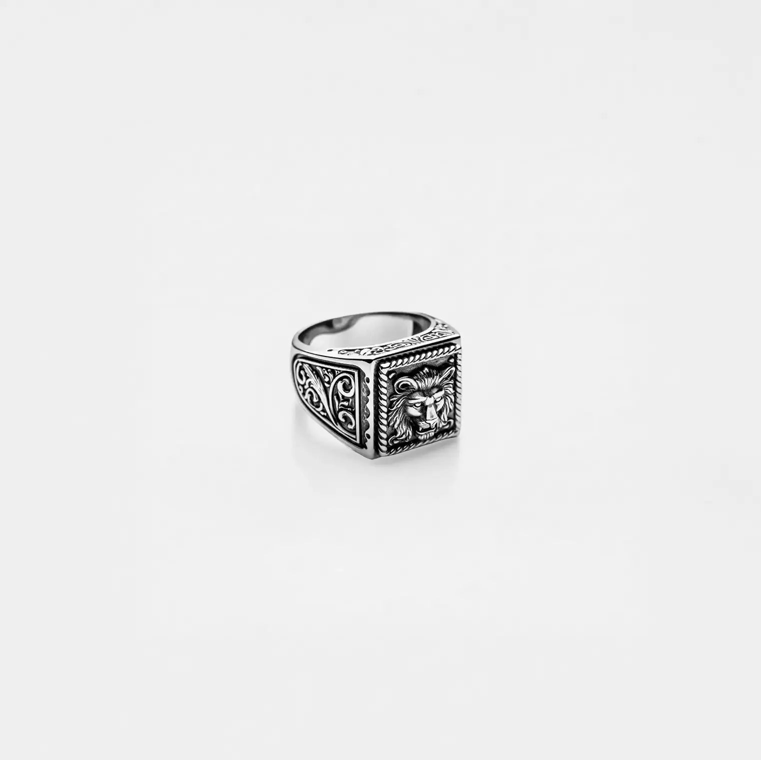 Silver ring with lion design on a light gray background