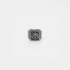 Silver ring with lion head design on a light gray background
