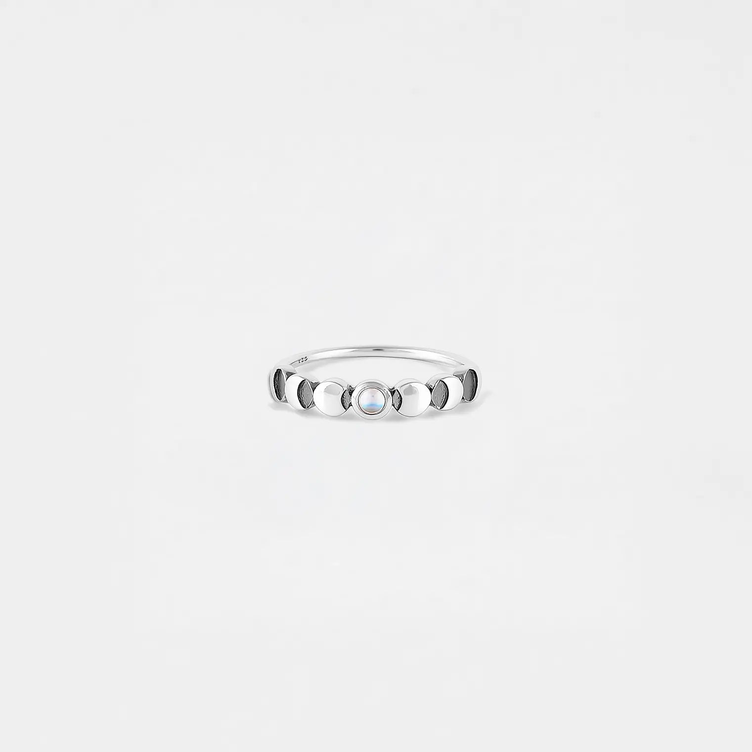 Silver ring of the lunar phase with a stone on a light gray background