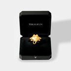 Gold manta ray ring in a black Tikalkun jewelry box on a light gray background