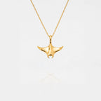 Gold MANTA RAY necklace on a light gray background