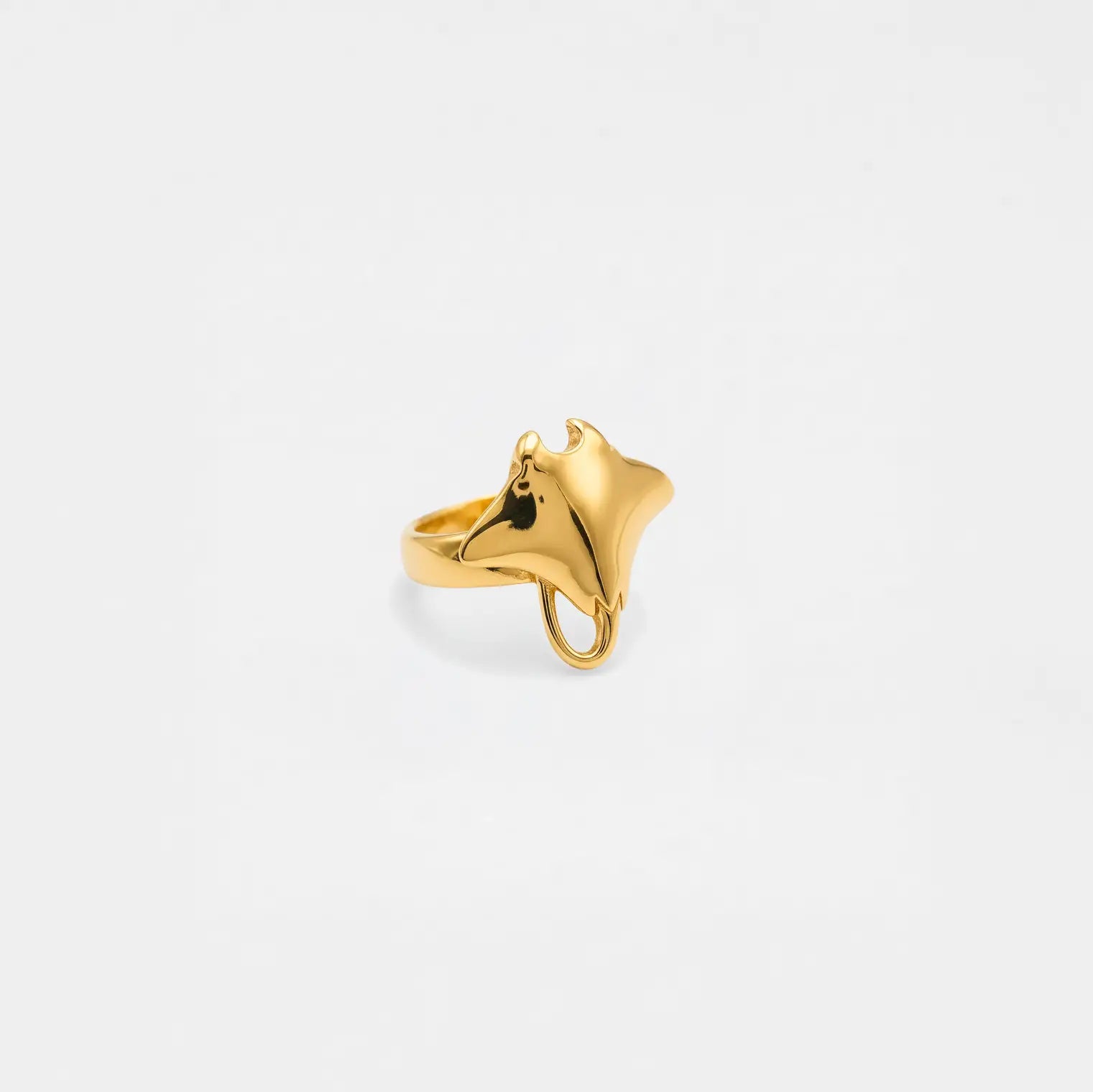Gold ring shaped like a stingray on a light gray background
