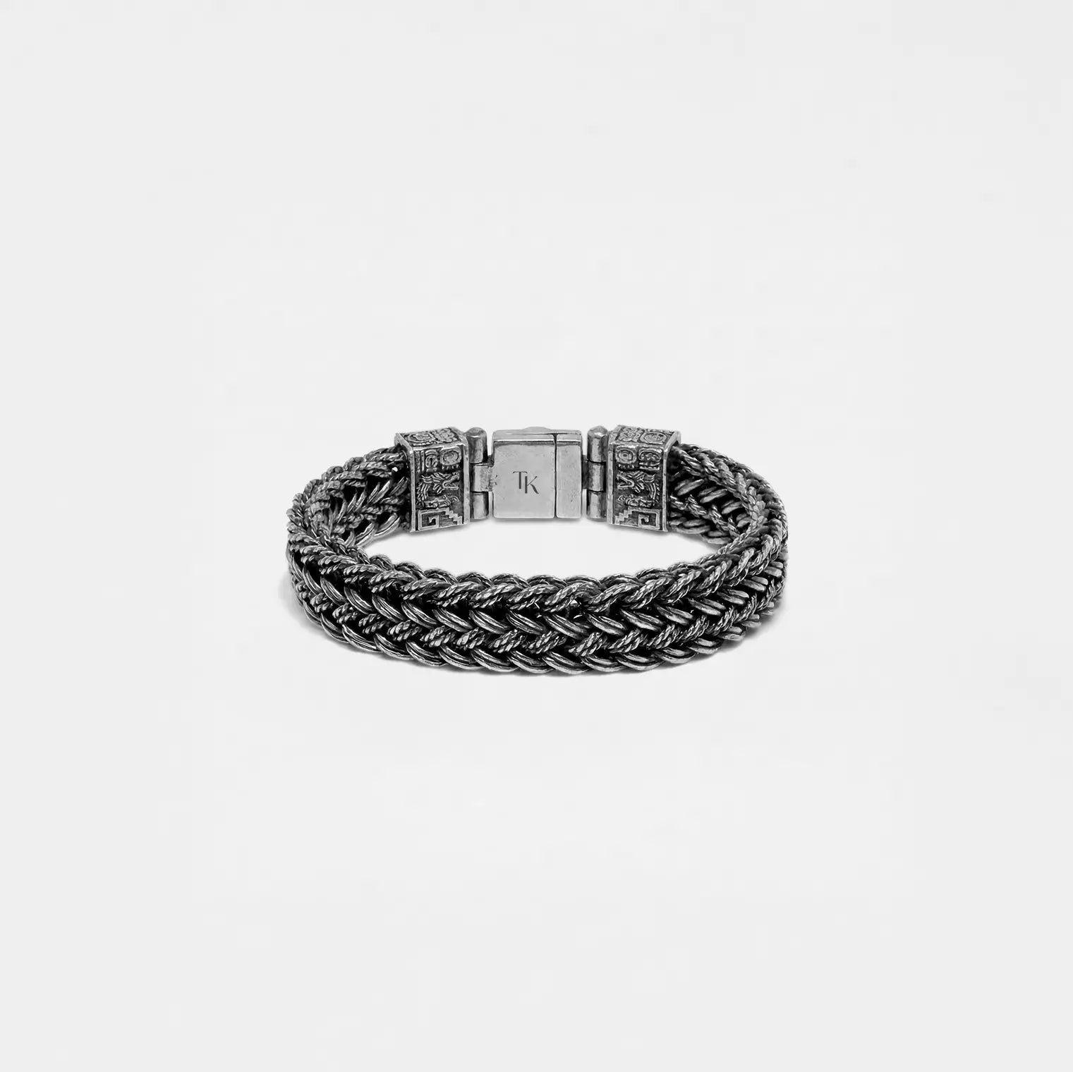 Silver braided bracelet on a light gray background