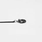 Silver heart pendant on a thin chain against a light gray background