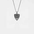 Silver necklace with a shield-shaped pendant on a light gray background