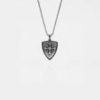 Silver necklace with a shield-shaped pendant on a light gray background