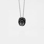 Necklace with a pendant featuring a medusa face design on a white background