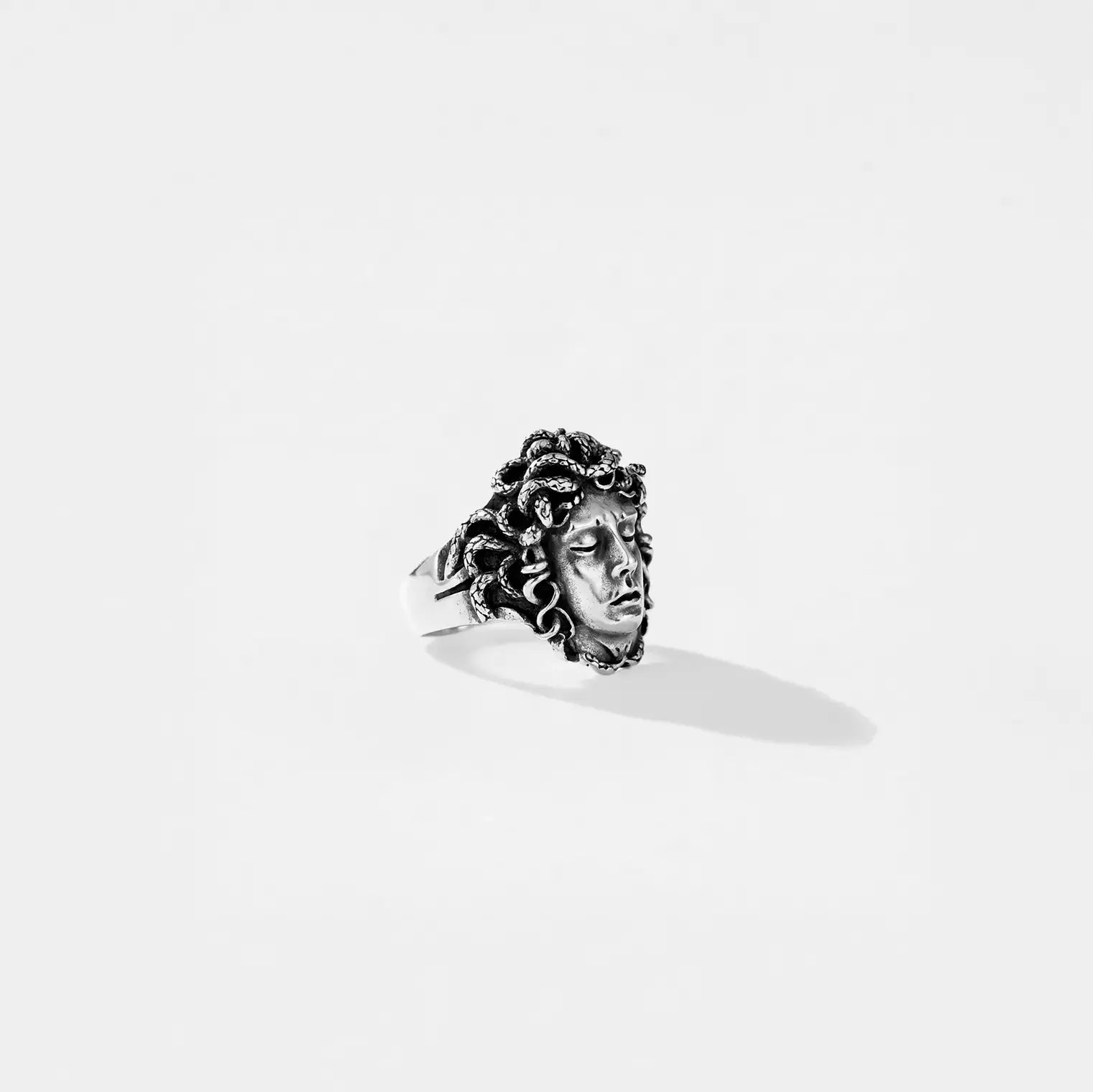 Silver ring with a MEDUSA face design on a white background