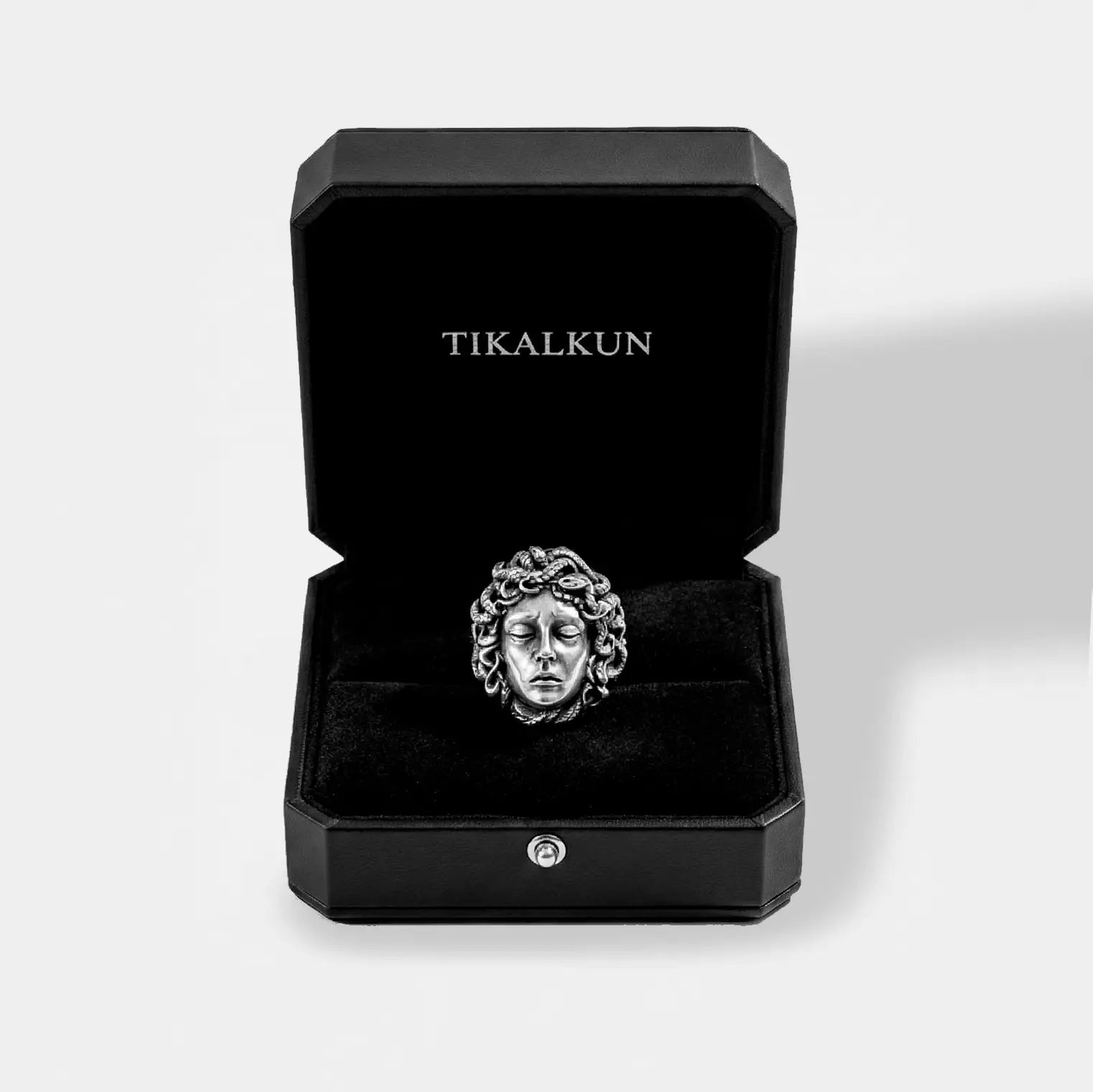 Silver ring with medusa design in a black Tikalkun box on a white background