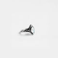 Silver ring with a pearl gemstone on a light gray background
